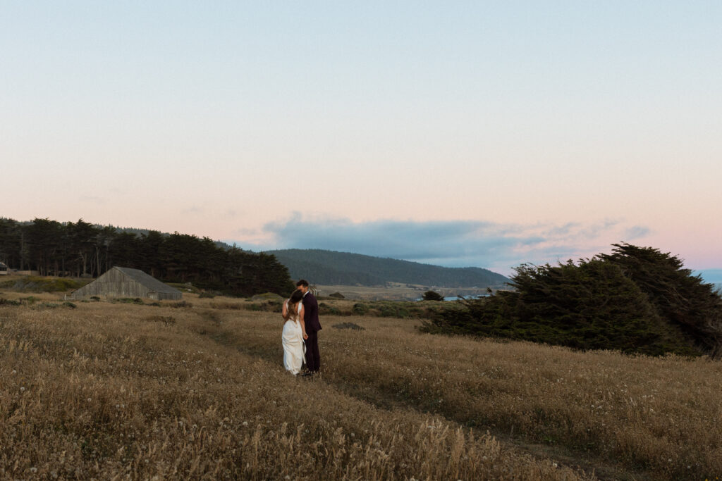 A wedding couple on the coast overlooking the ocean.