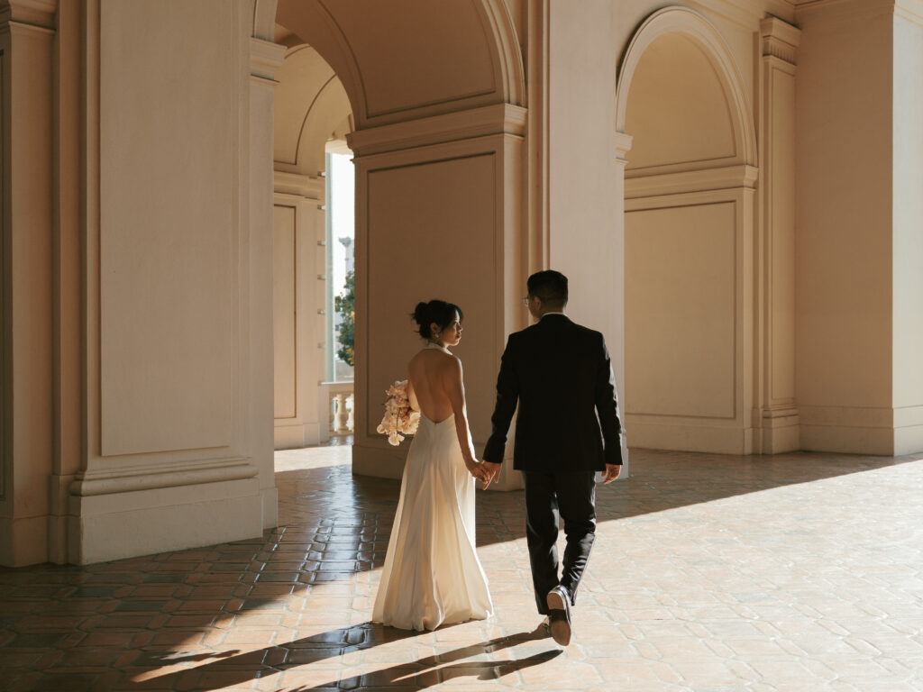Bride and Groom walk an architectural space