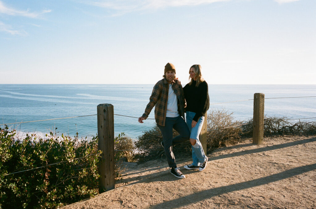 The beach is a perfect Los Angeles Engagement Photo Locations - like this couple overlooking the pacific ocean, dressed fashionably.