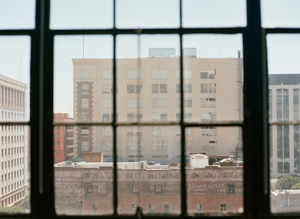 A photograph of Downtown Los Angeles architecture through a window.