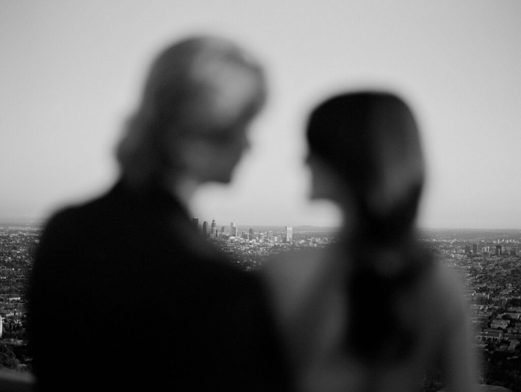 A black and white photograph of a blurred couple overlooking the city after their Los Angeles Elopement