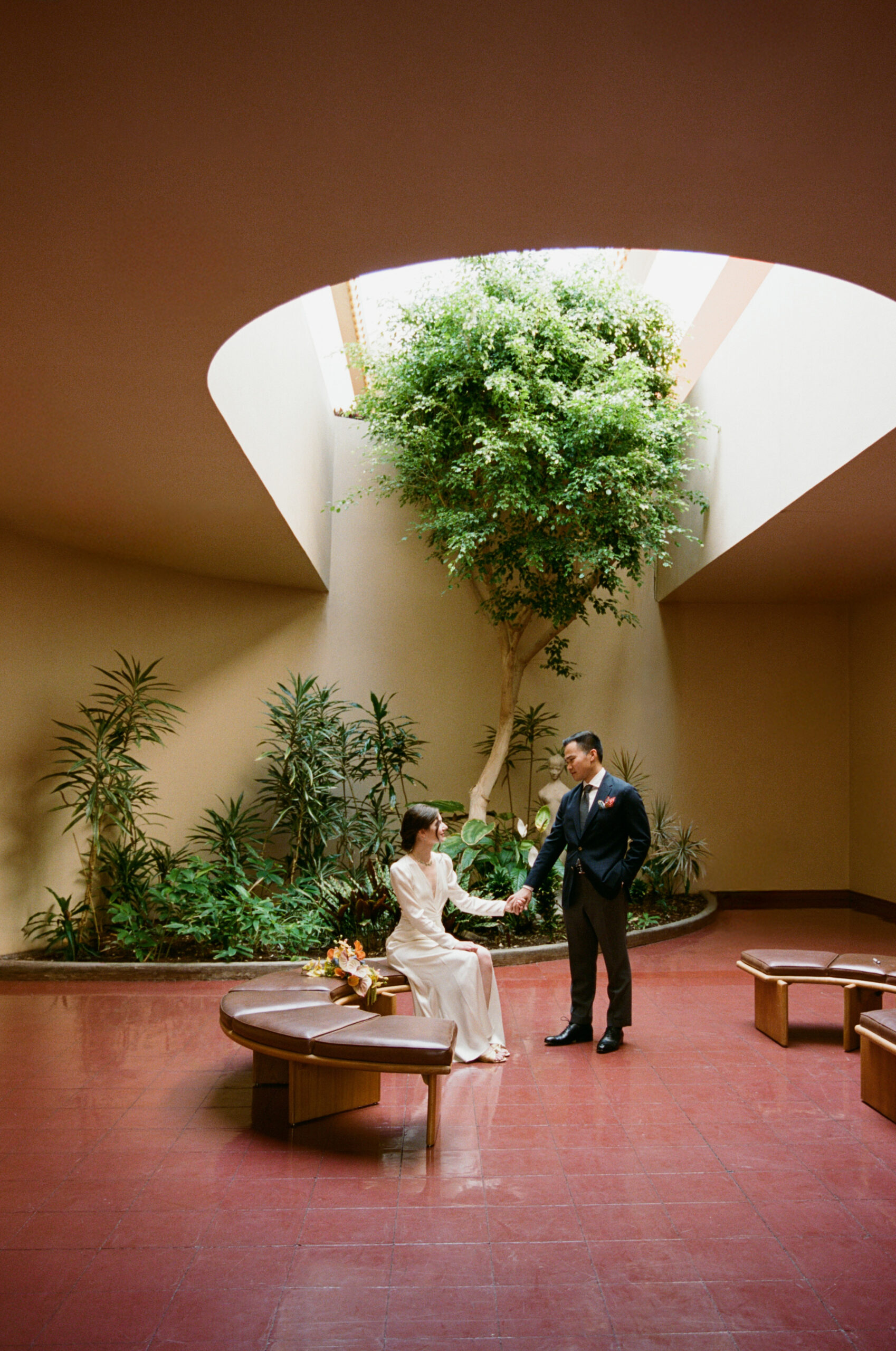 Bride and groom standing in architectural space